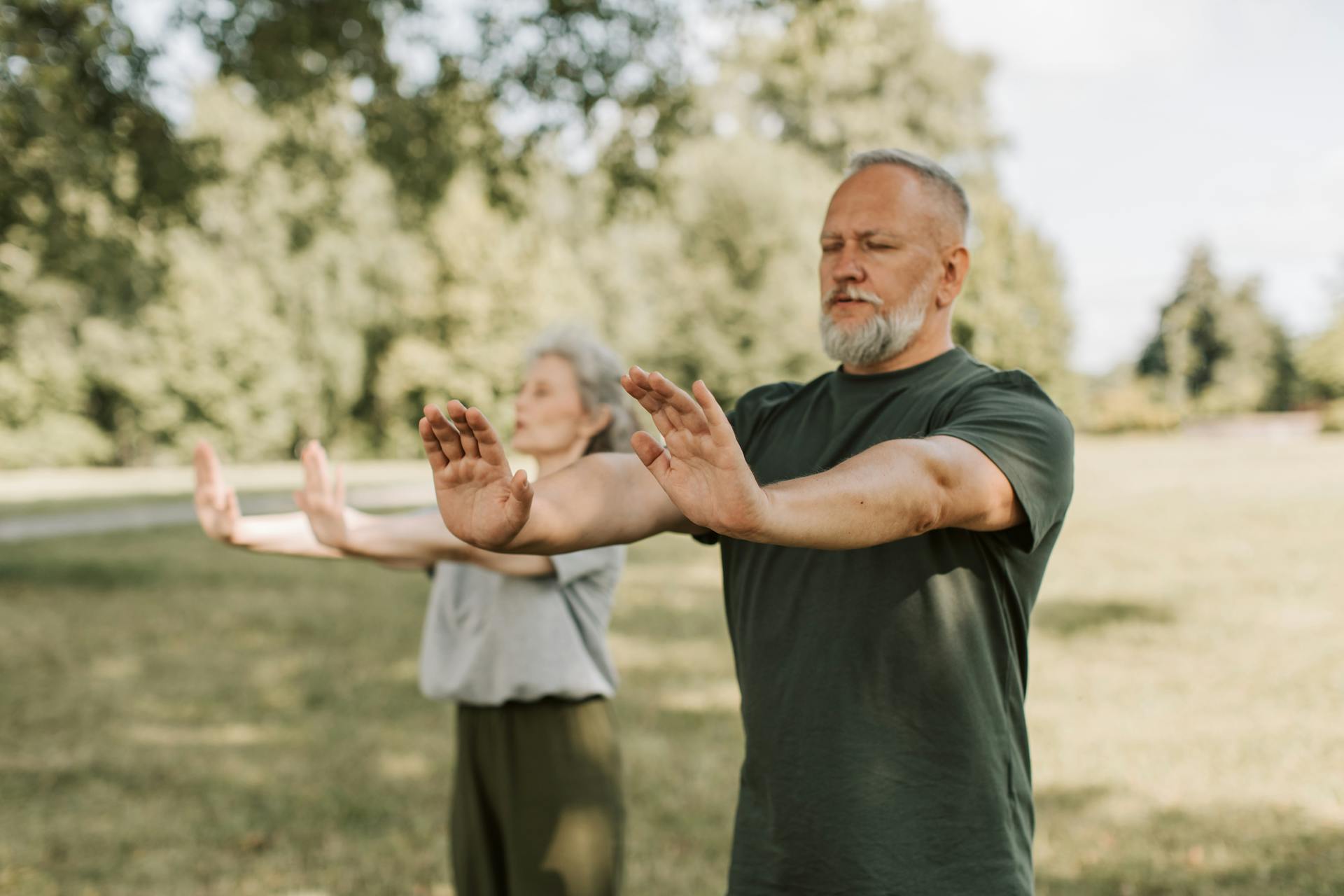 Starszy mężczyzna ćwiczy Qi Gong w plenerze